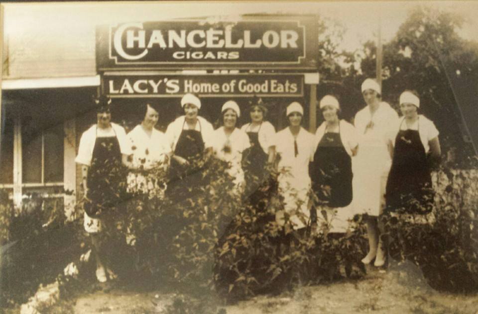 A group of people standing in front of a sign.