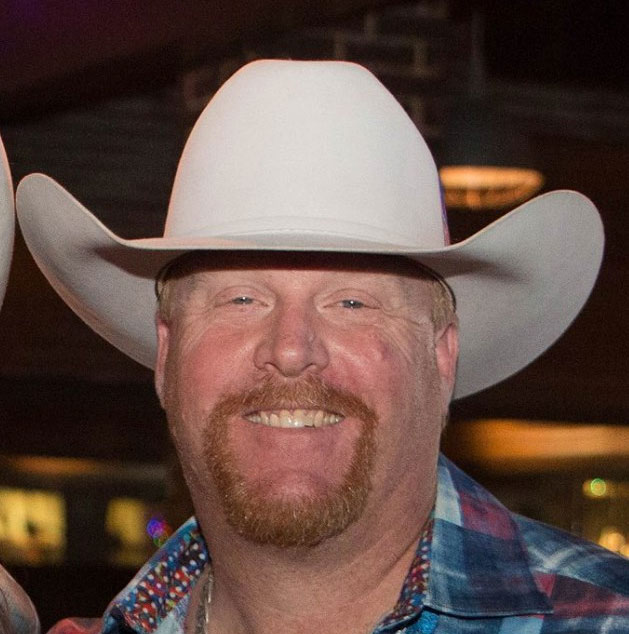 A man with a white cowboy hat on.