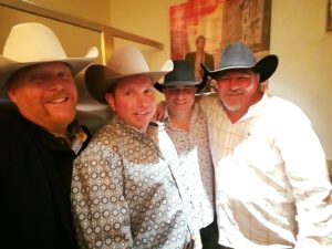 A group of people in cowboy hats posing for the camera.