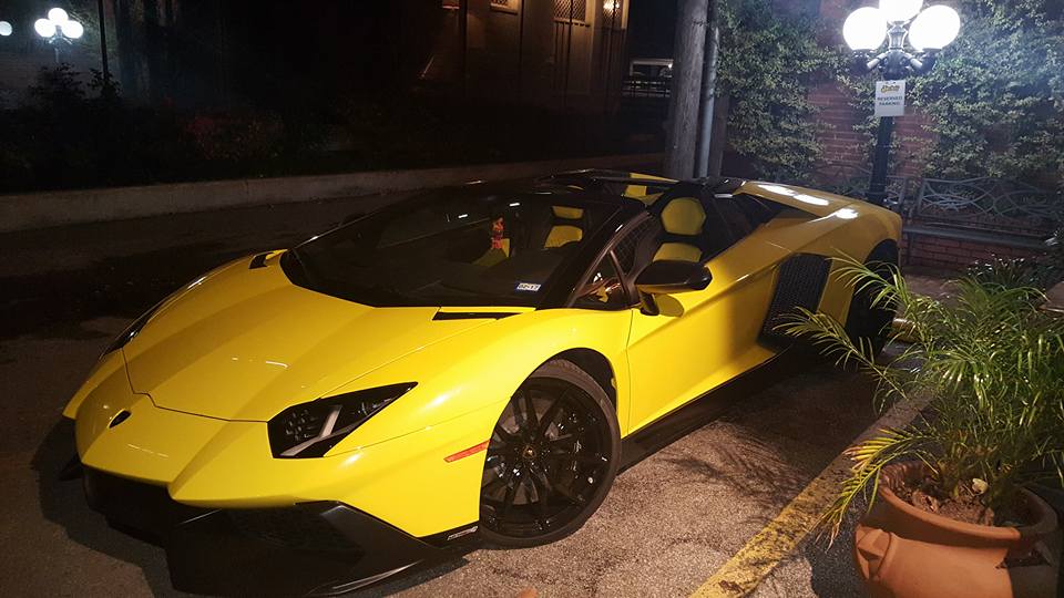 A yellow lamborghini parked on the side of a road.