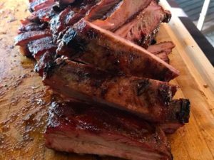 A close up of some ribs on a wooden board
