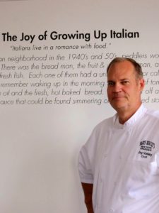 A man standing in front of a wall with an italian quote.