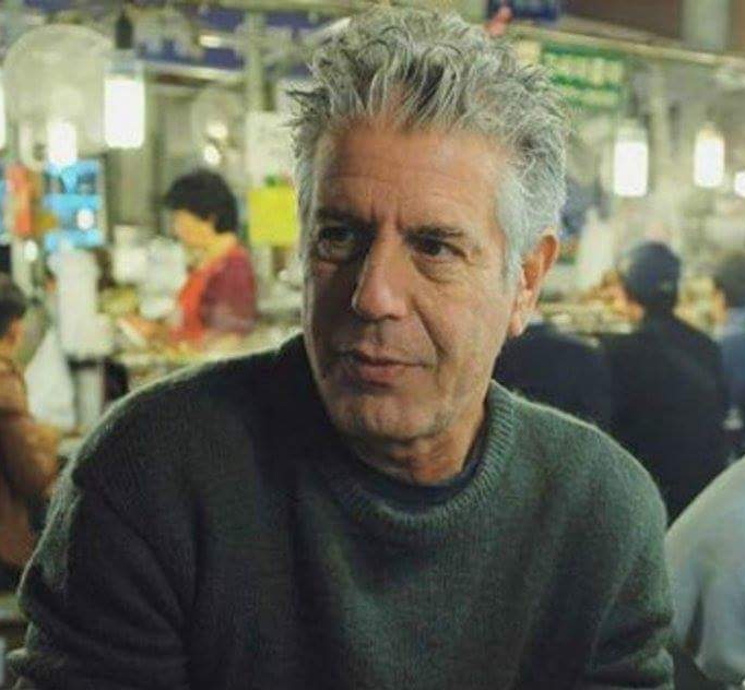 A man with grey hair sitting at a table.