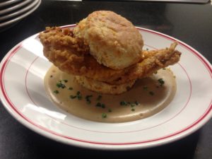 A plate with some fried chicken and biscuits on it