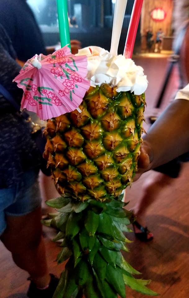 A pineapple with an umbrella on top of it.