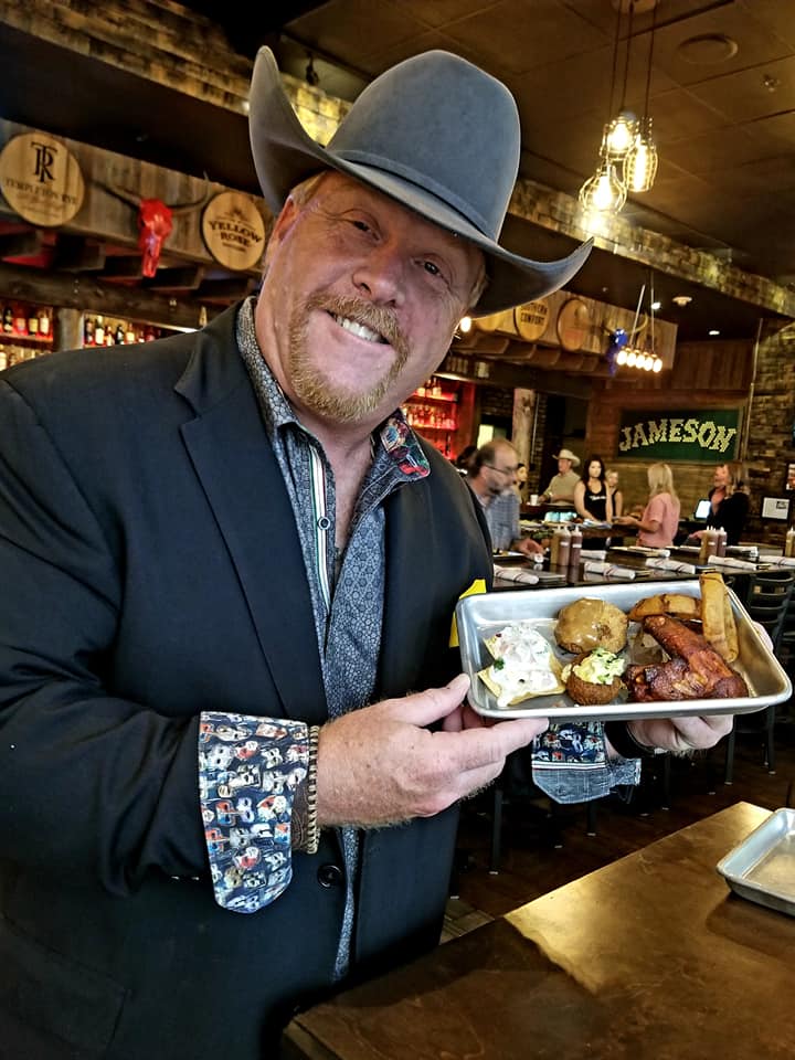 A man holding a tray of food in front of him.