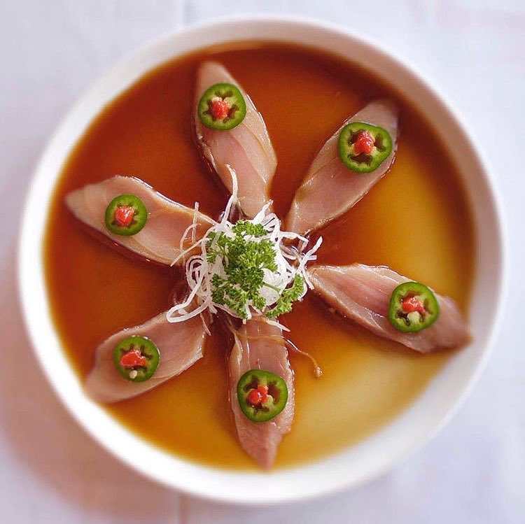 A bowl of soup with six different types of food in it.