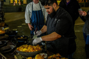 A man in an apron is cooking food.