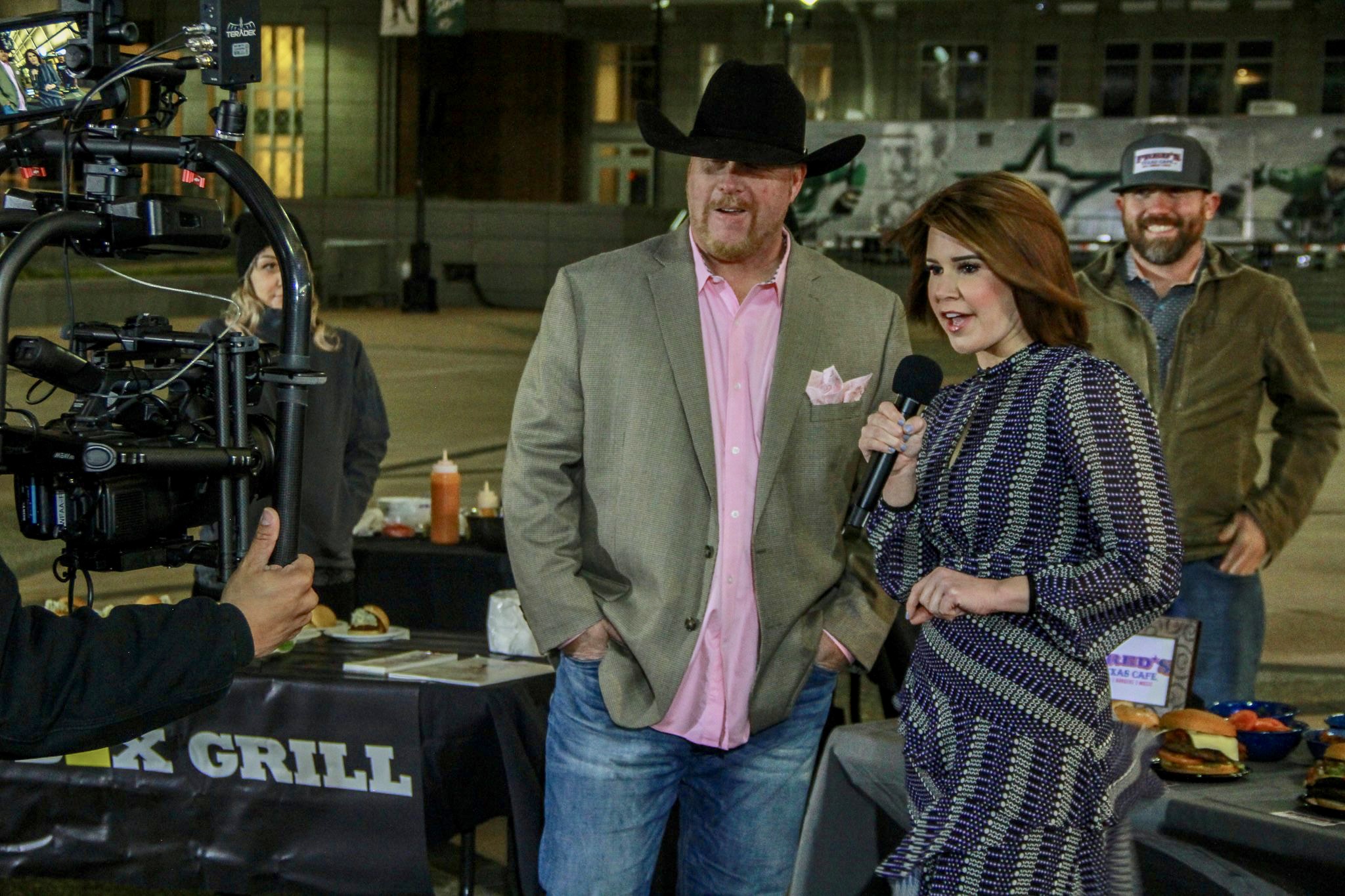 A man and woman are standing in front of a microphone.