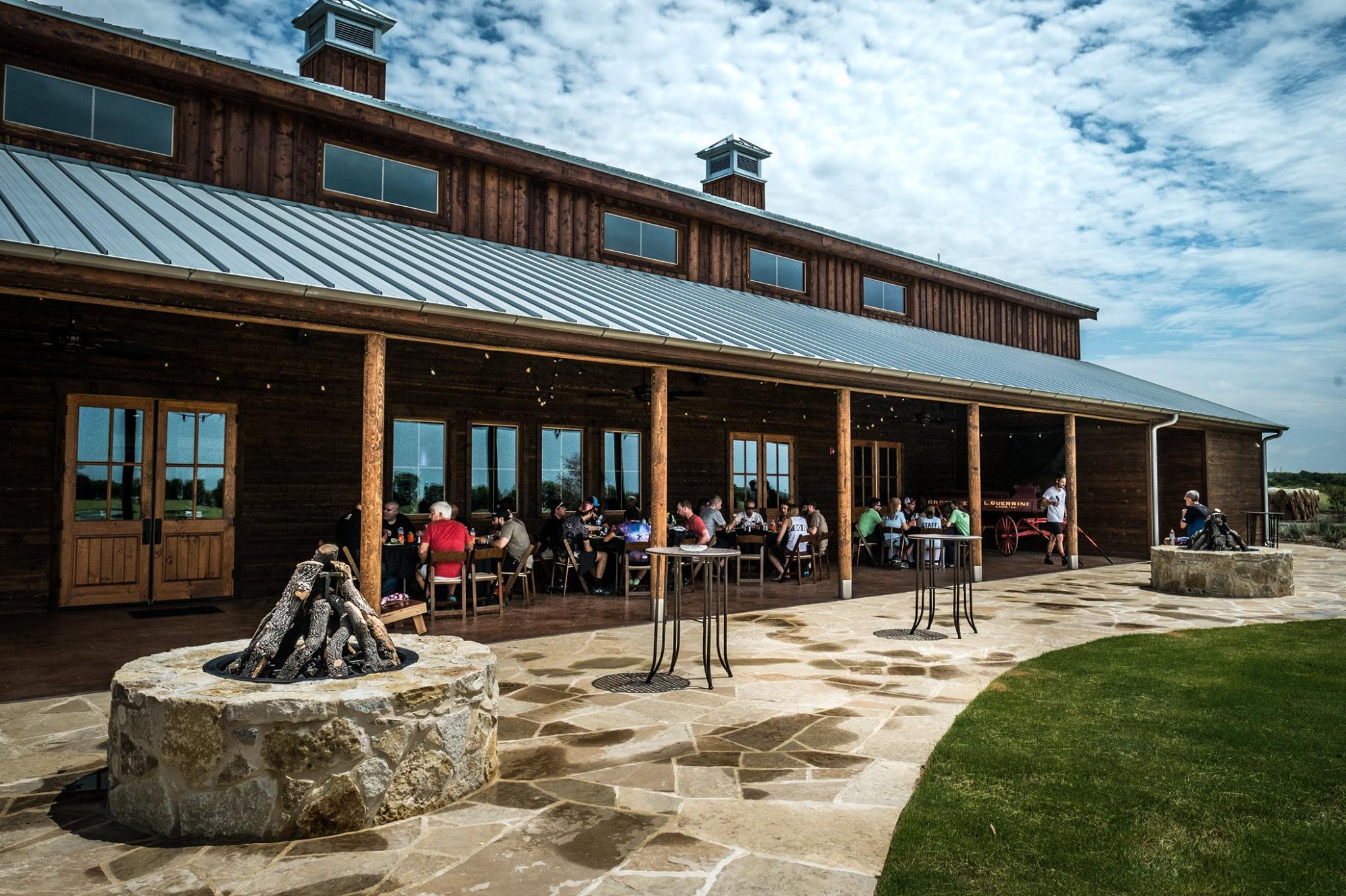 A group of people sitting outside at tables.