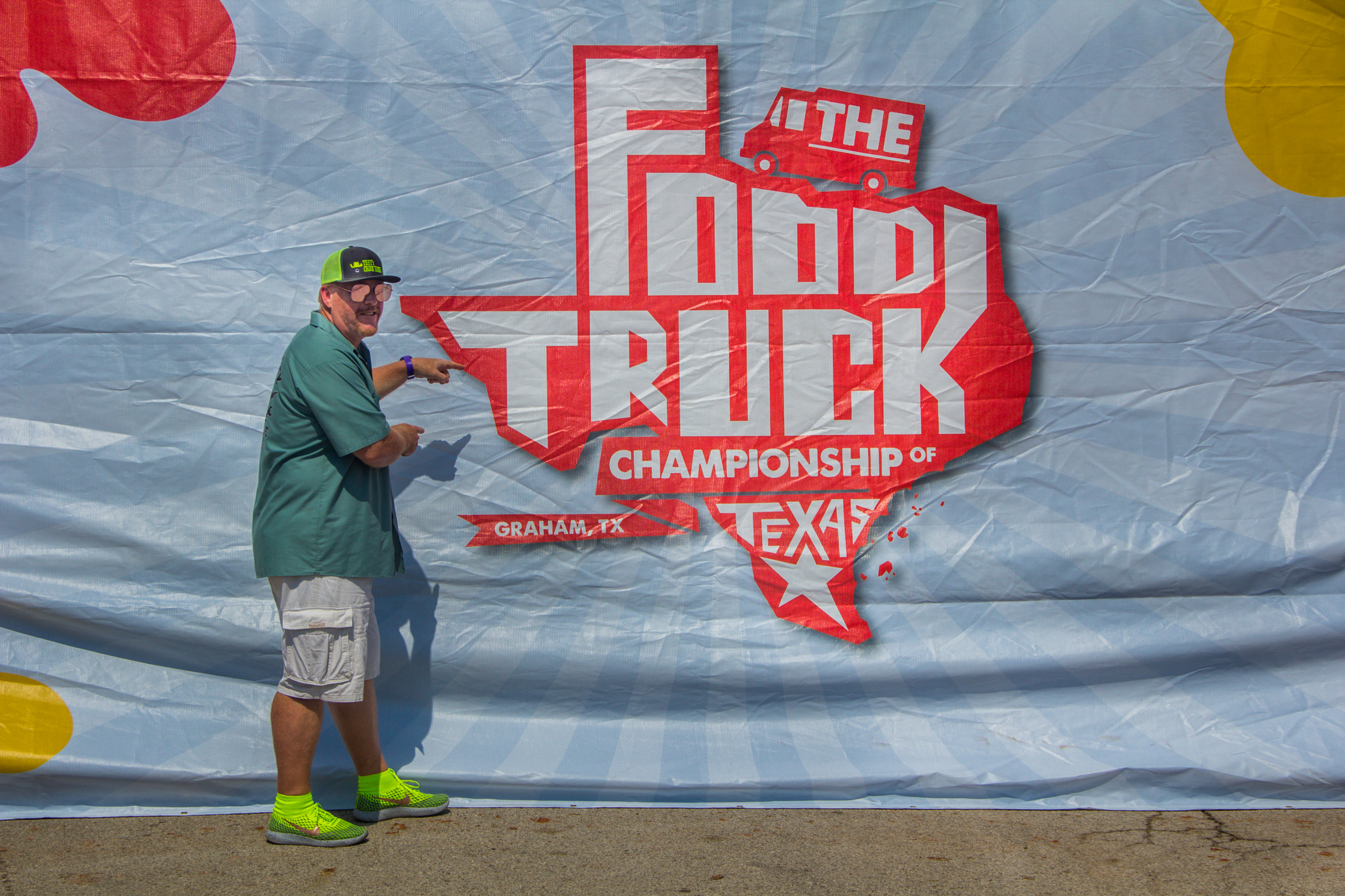 A man standing in front of a large sign.