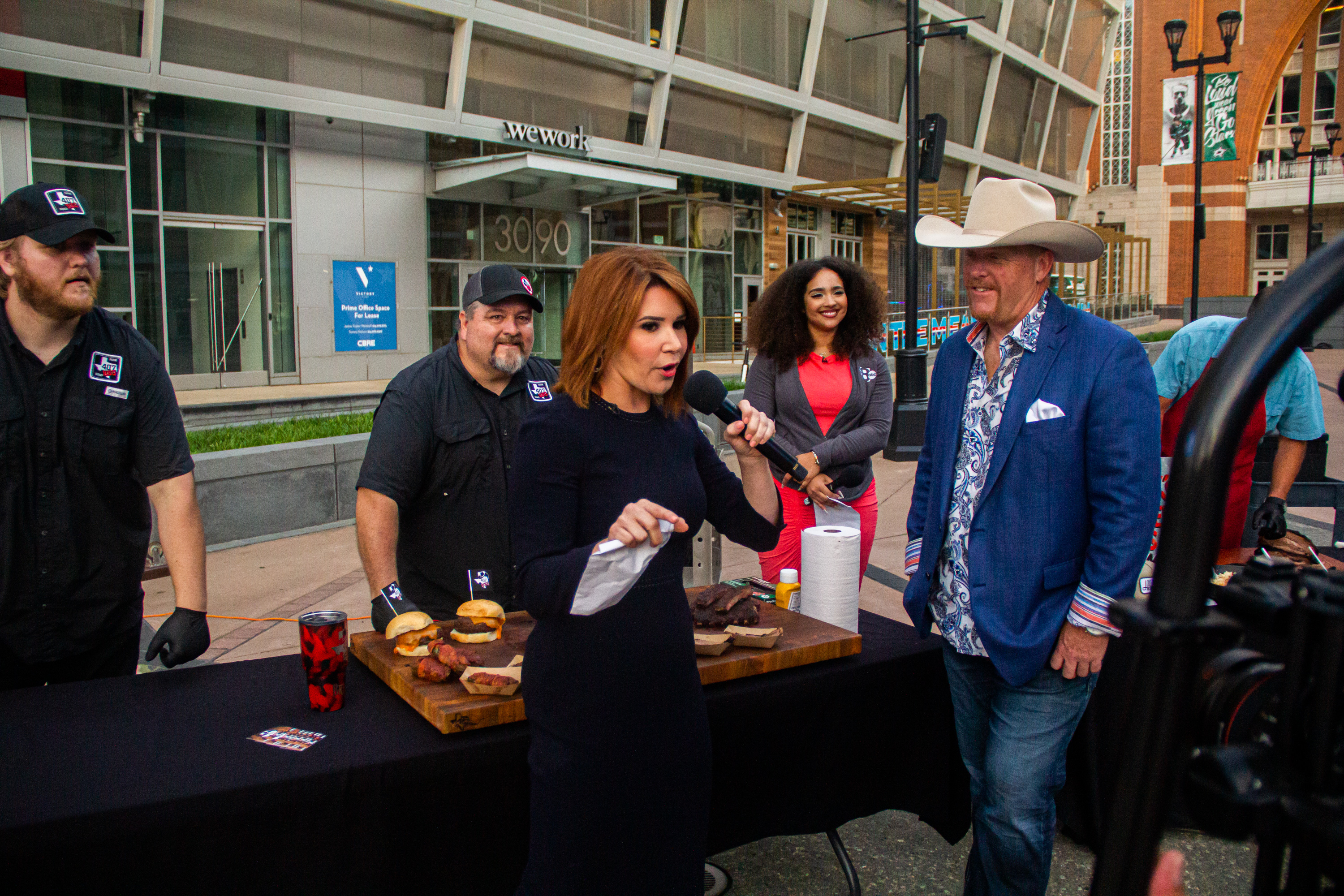 Two men standing next to a table with meat on it.