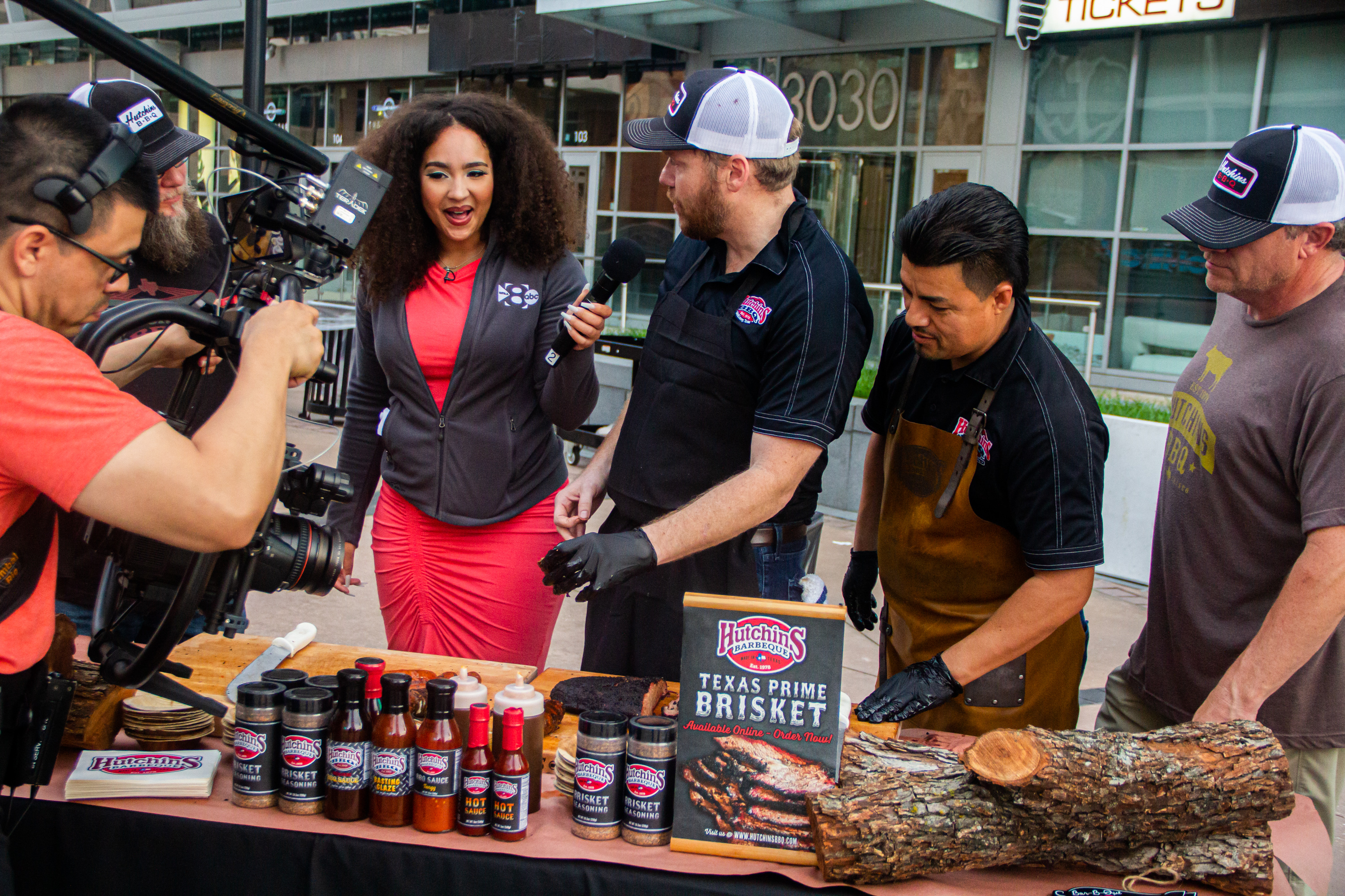 Two men standing next to a table with meat on it.