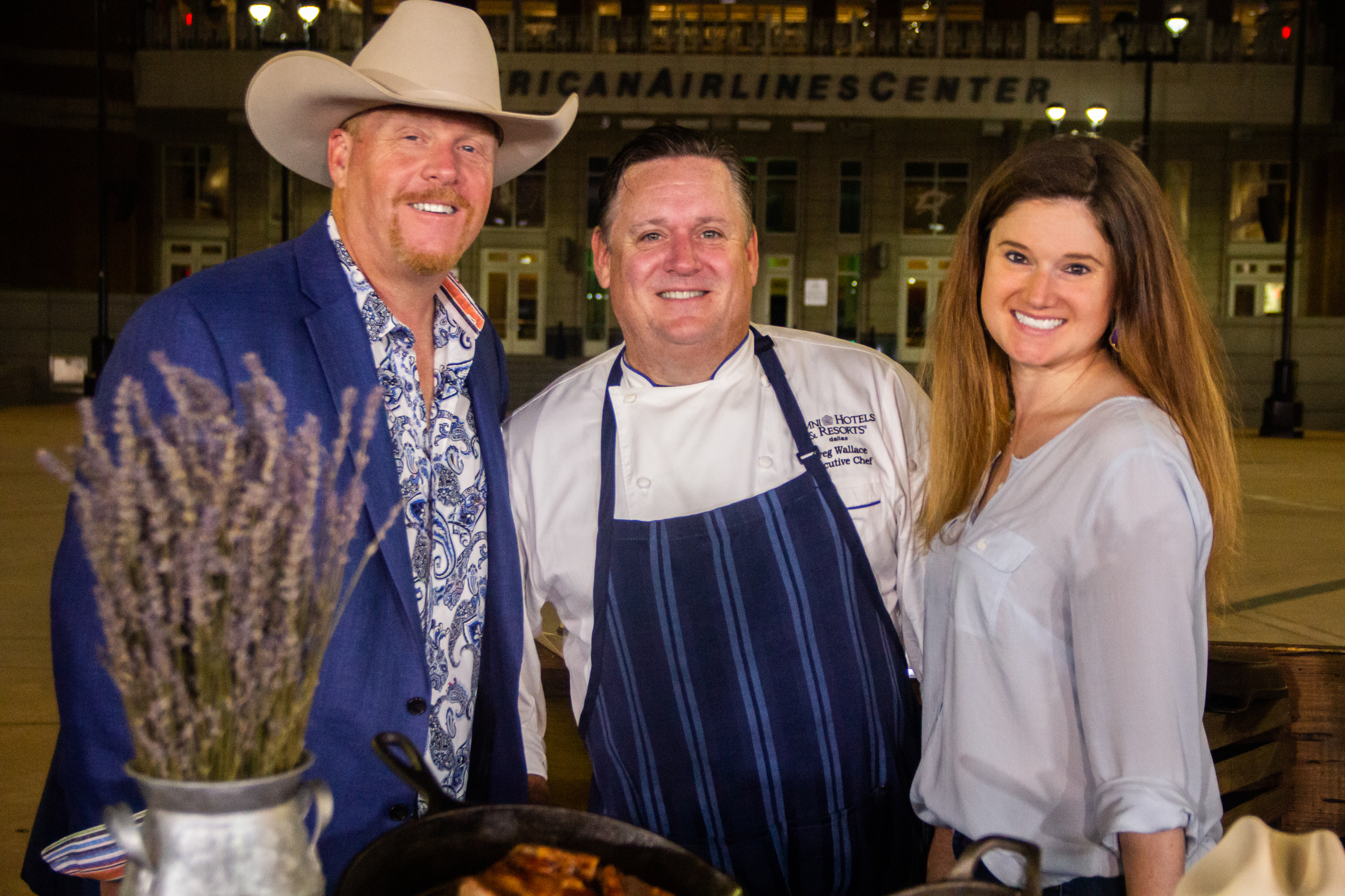 A group of people standing around a grill.