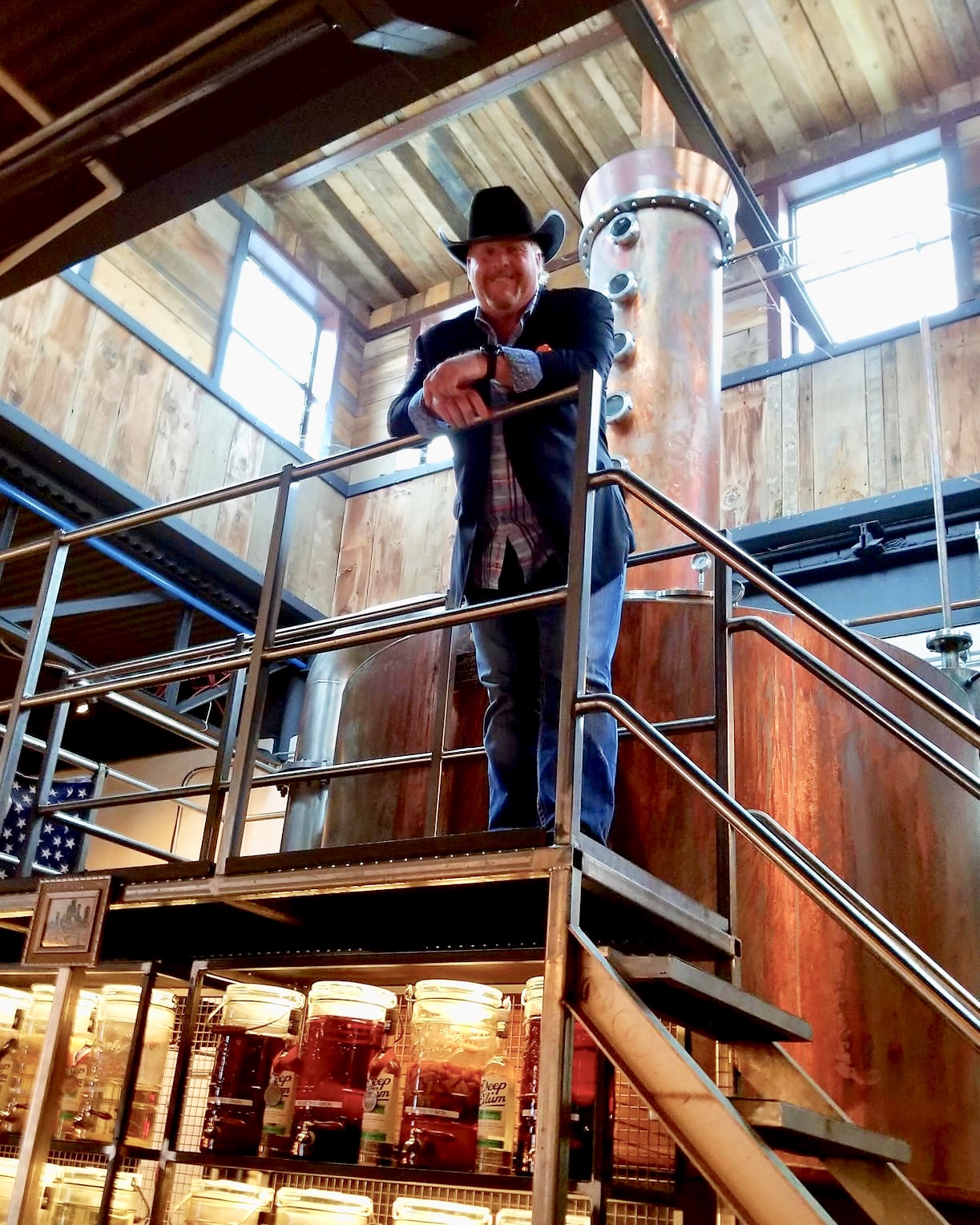 A man in a cowboy hat standing on top of stairs.