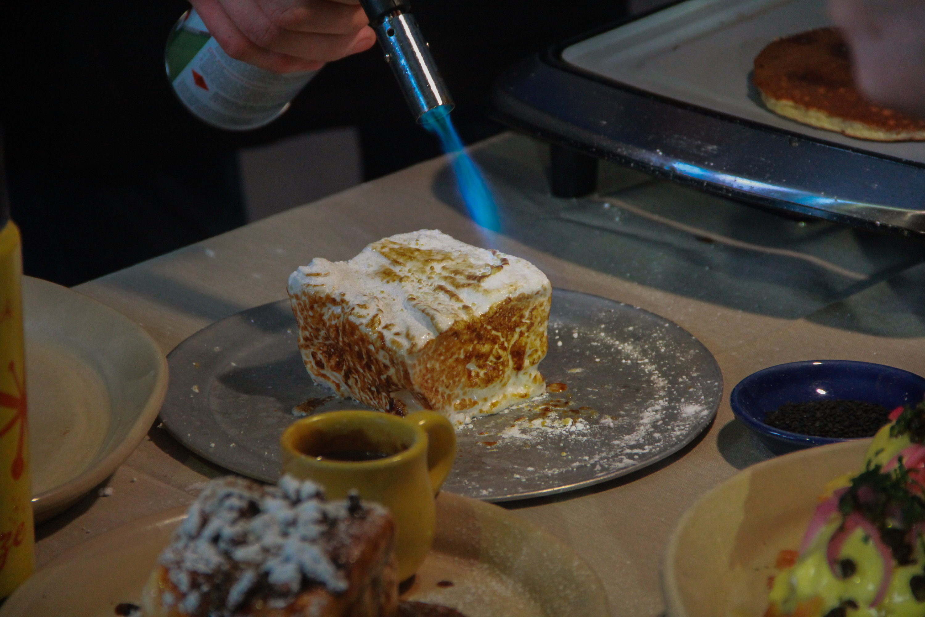 A person is cutting into some cake on the table