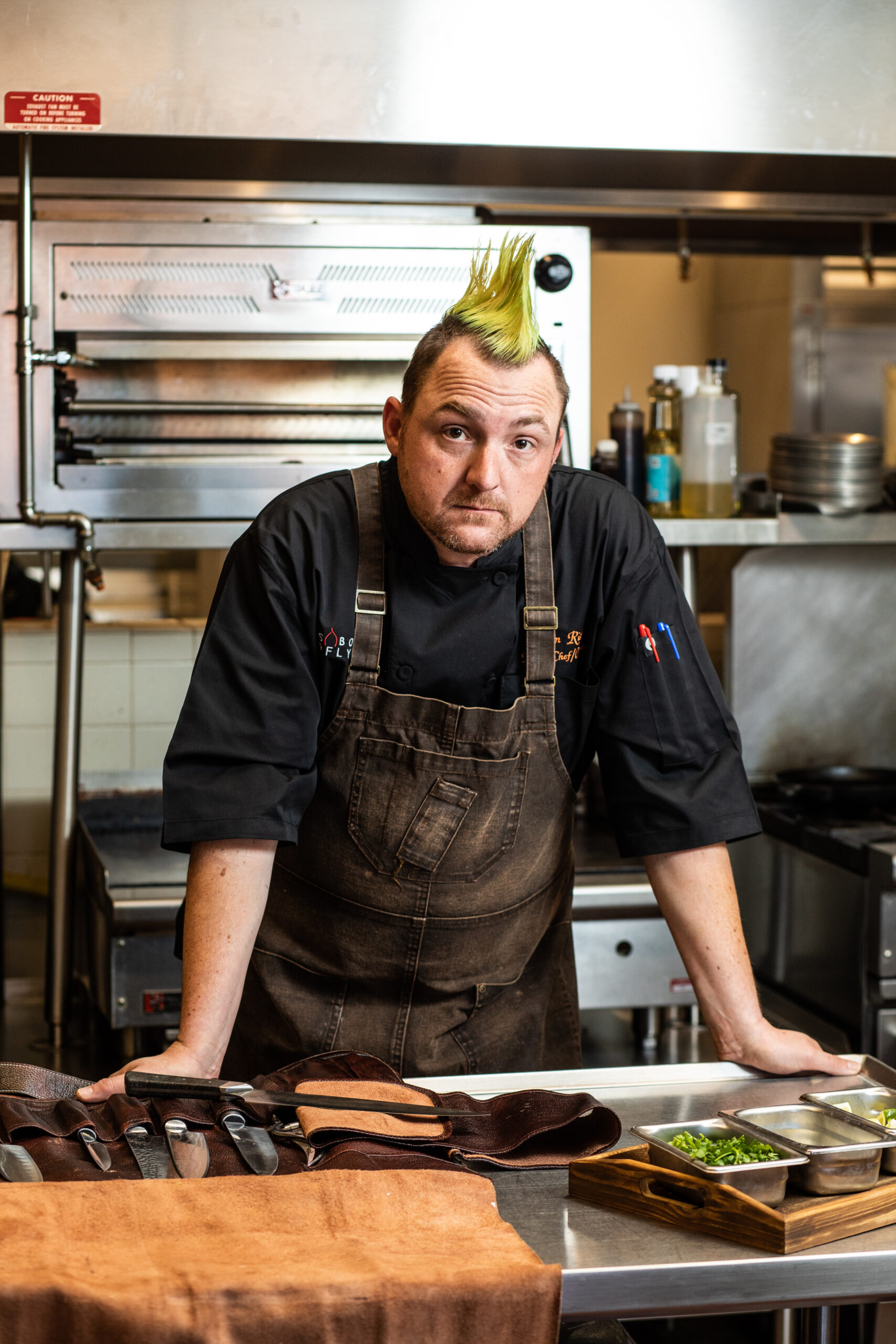 A man with a mohawk in the kitchen.