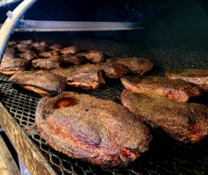 A grill with several different types of meat on it.