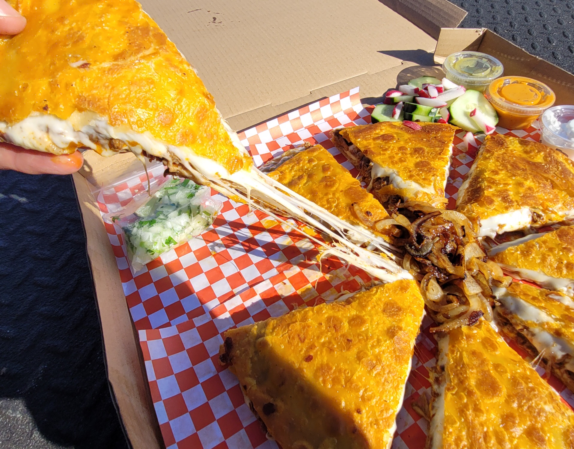 A pizza sitting on top of a box covered in cheese.