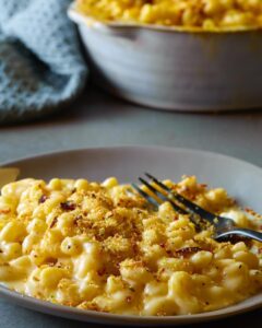 A plate of macaroni and cheese with a fork.