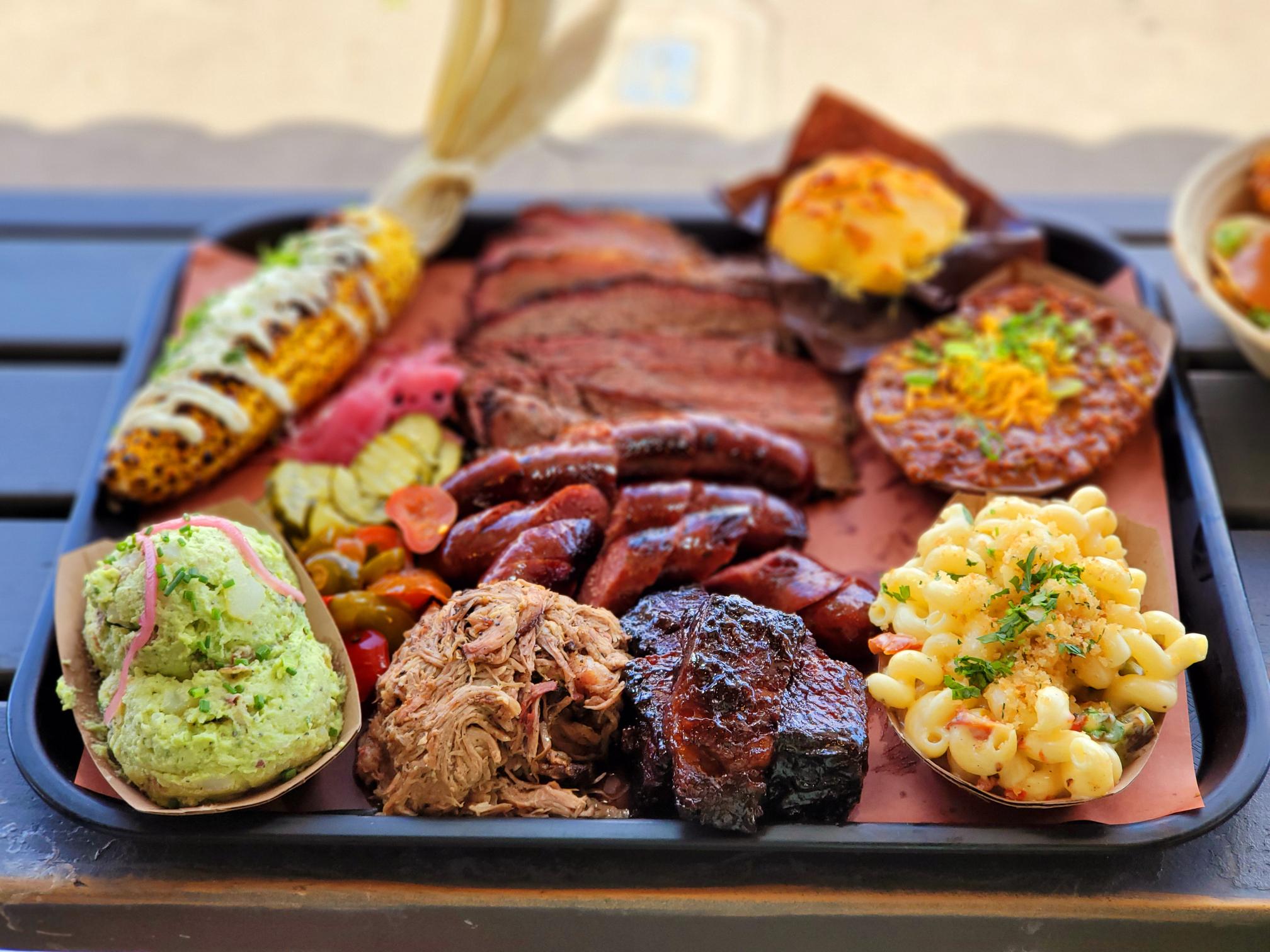 A tray of food with meat, corn and potatoes.