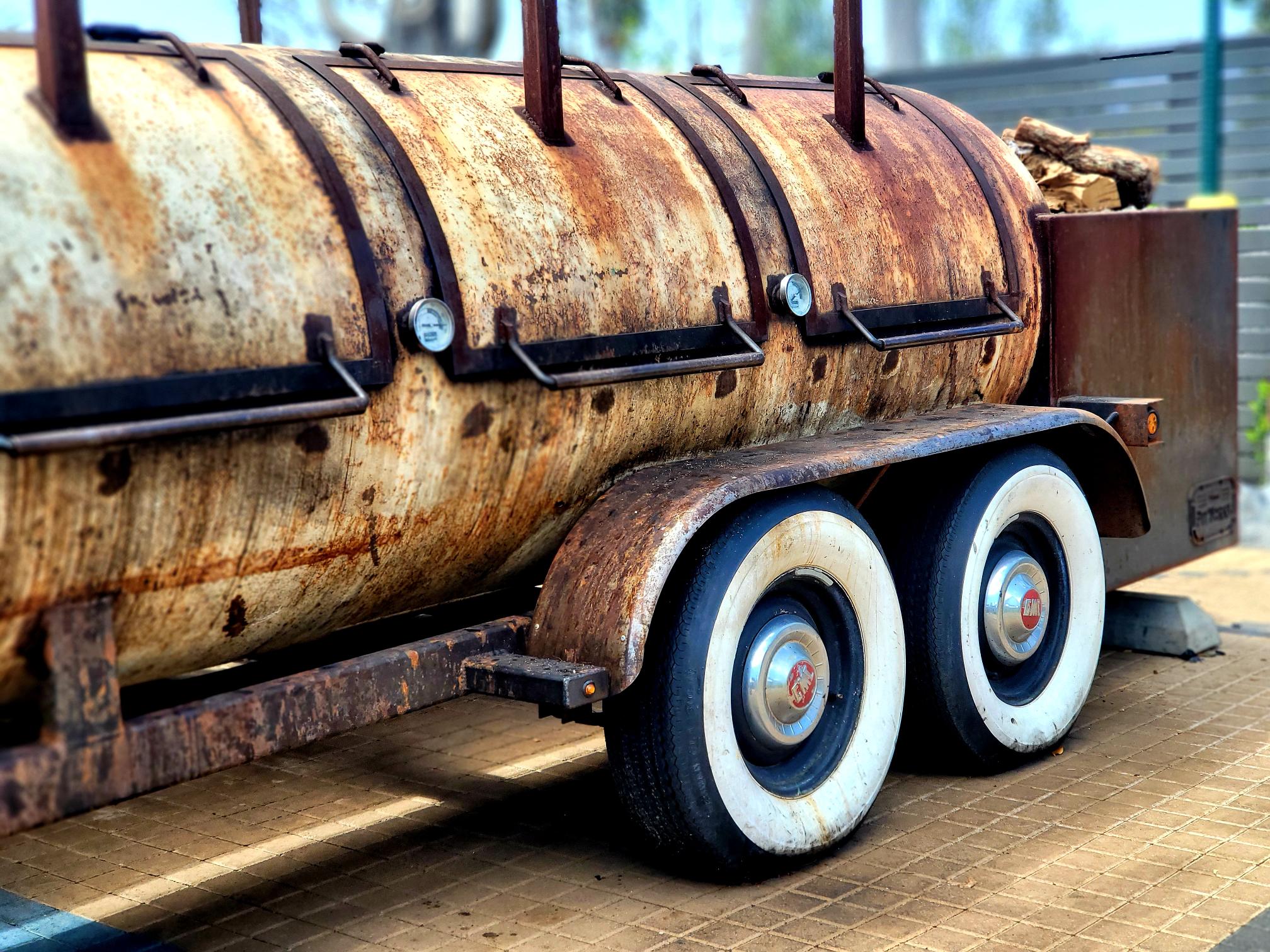 A rusted tanker trailer with white wheels.