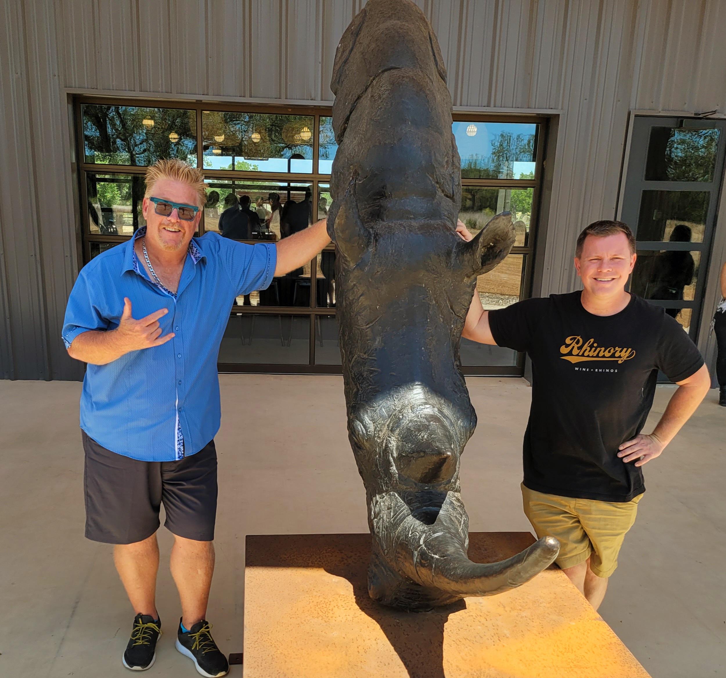 Two people standing next to a statue of an elephant.