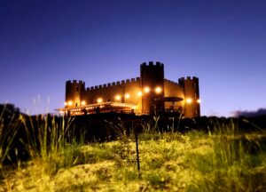 A castle like building with lights on it's side.
