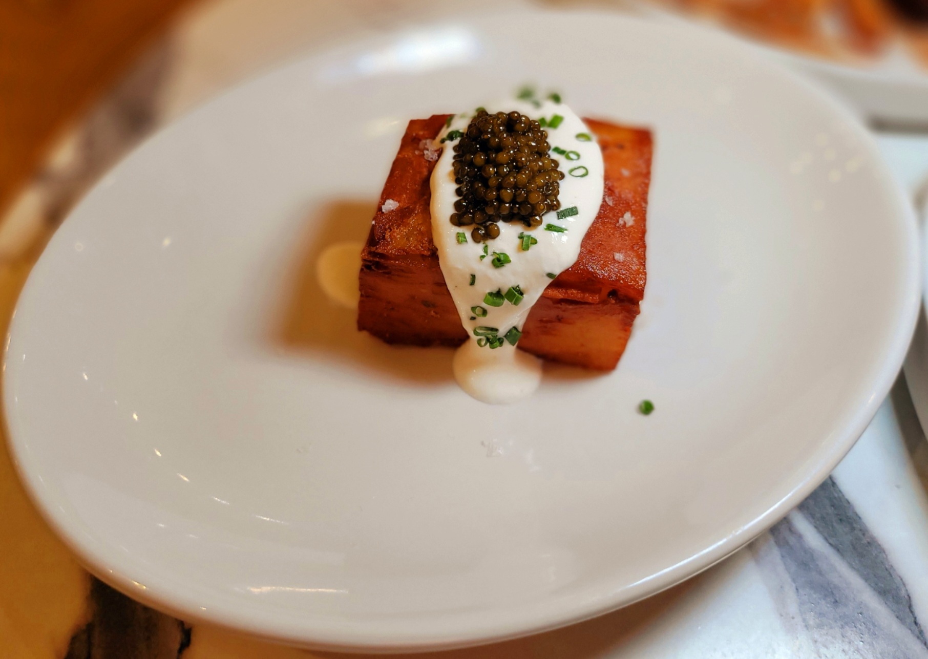 A white plate topped with food covered in sauce.