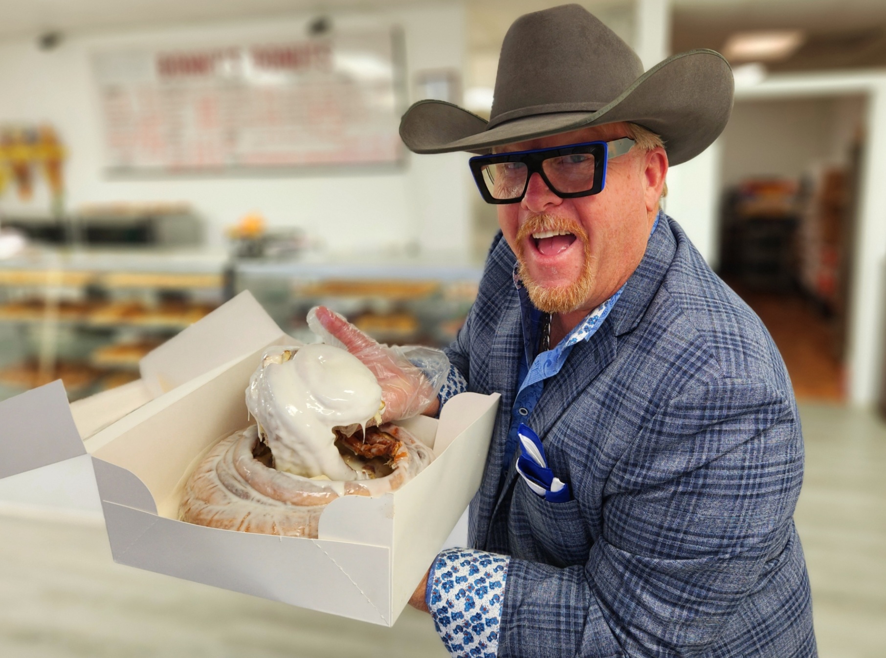 A man holding an open box of donuts.