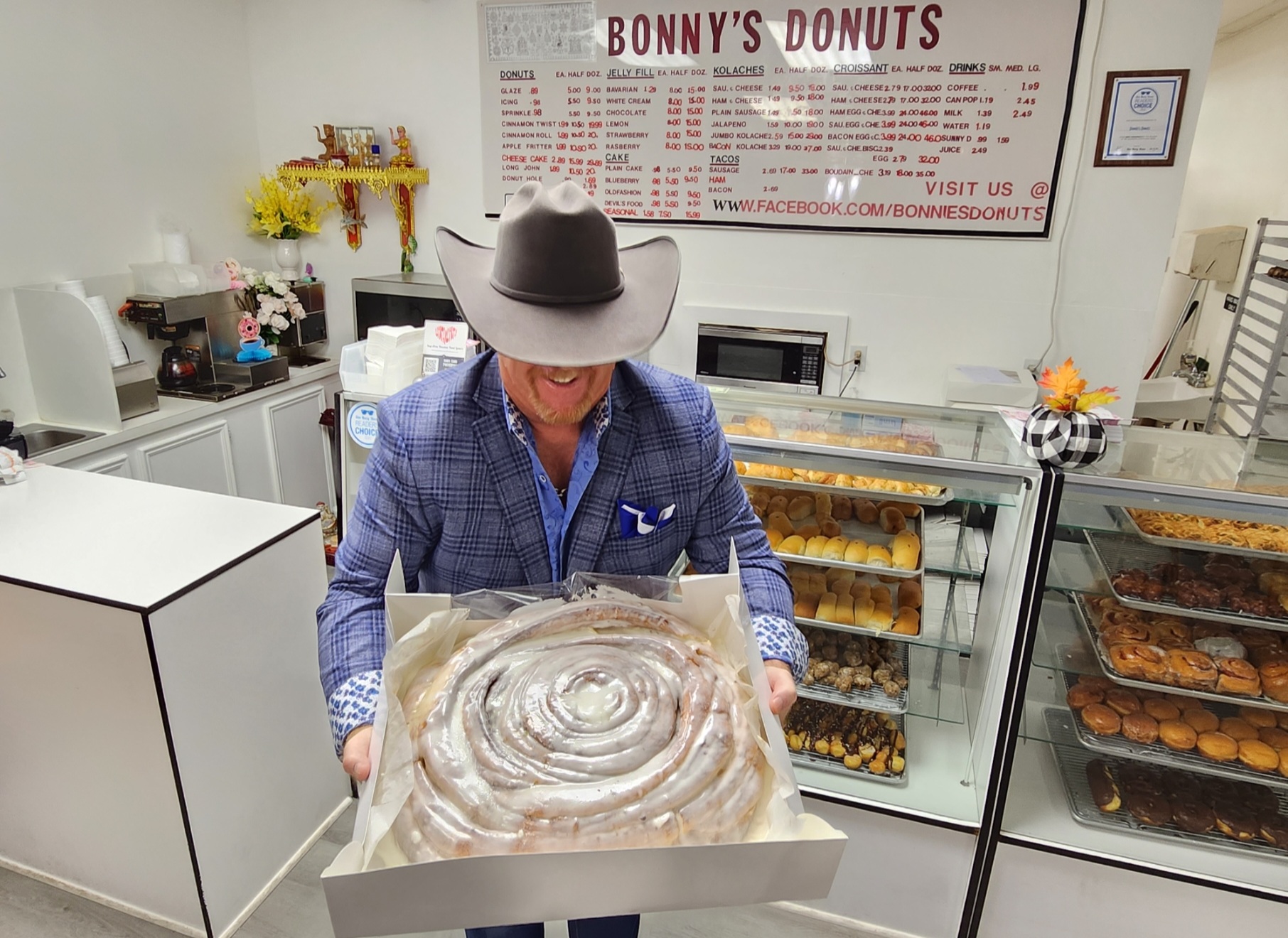 A man holding an open box of donuts.