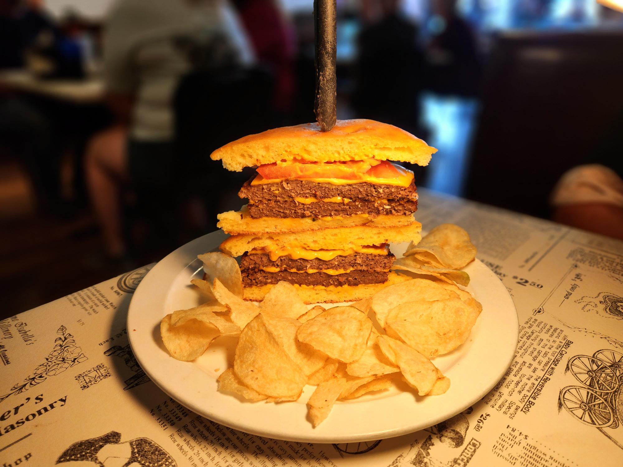 A plate with two sandwiches and chips on it