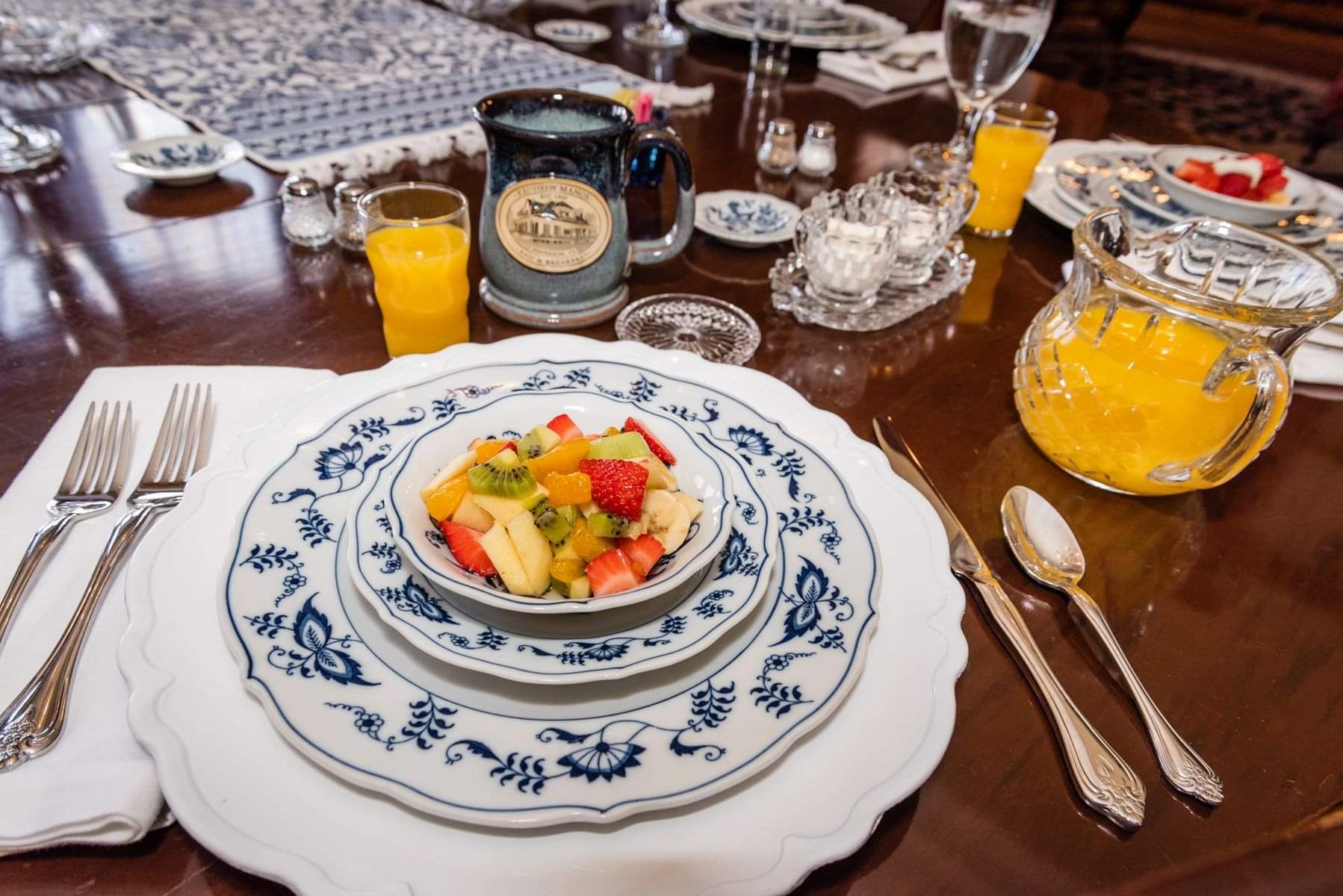 A table with plates and bowls of fruit.