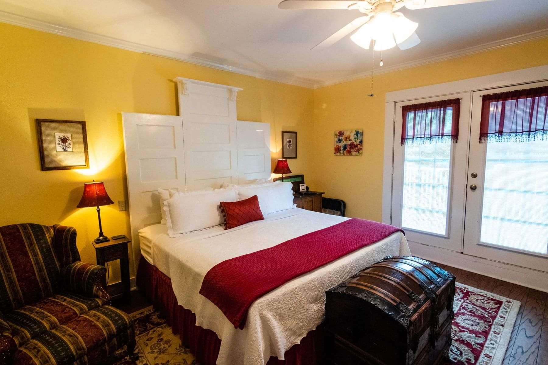 A bedroom with a bed, dresser and window.