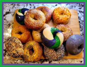 A wooden board topped with lots of different types of donuts.