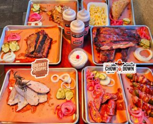 A table with several trays of food on it.
