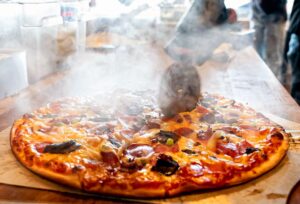 A pizza with smoke coming out of it.