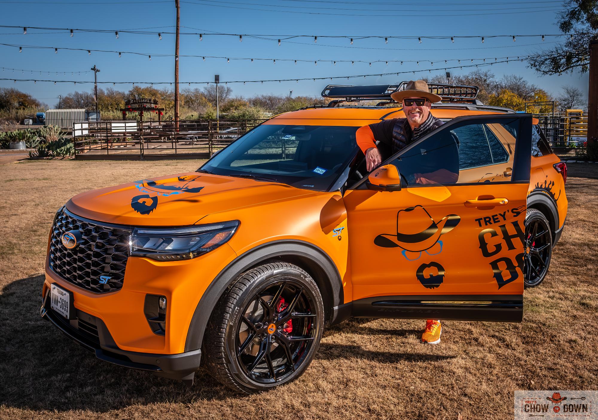 A man standing next to an orange truck.